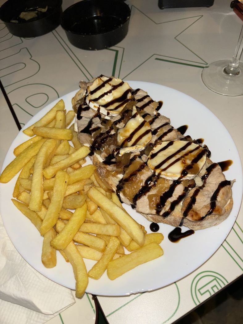 Tosta de solomillo con queso de cabra, cebolla caramelizada y patatas fritas.